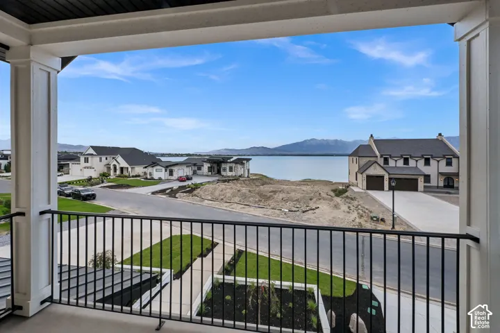 Balcony with black metal railings, white columns, and a dark wood-finish ceiling