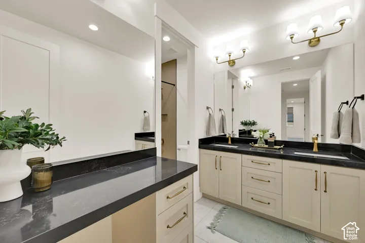Dual vanity with undermount sinks, black countertops, and gold-finish fixtures