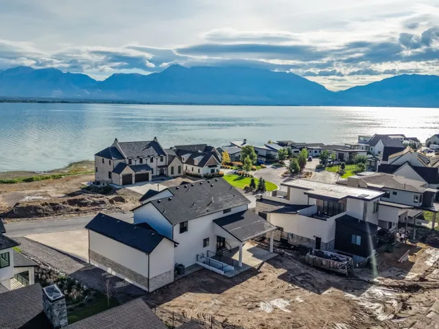 Waterfront residential community featuring modern architectural design with varied rooflines, expansive landscaping, and panoramic vistas of mountains and water
