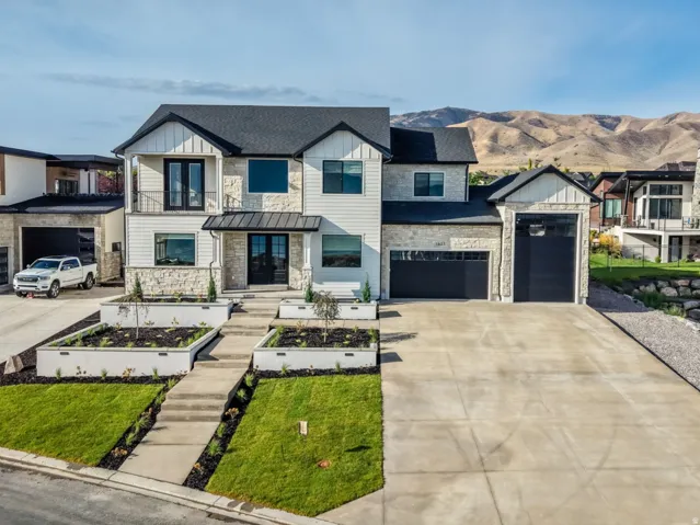 Modern two-story residence featuring a clean-lined facade with mixed material cladding, multi-pane windows, and a dark-framed entry door