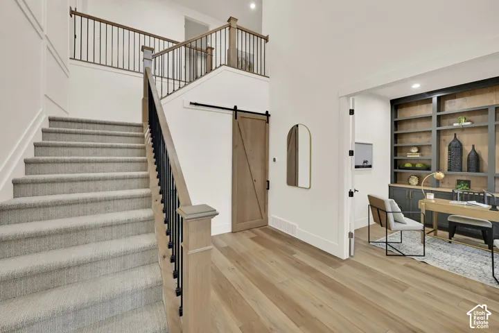 Carpeted staircase with black metal balusters and wood handrails