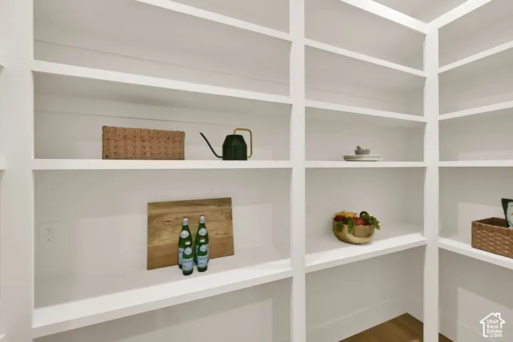 Built-in shelving with multiple levels, white finish, and wood-finish flooring