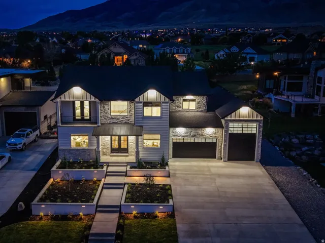 Two-story residence featuring a mixed-material facade with stone accents, horizontal siding, and vertical board-and-batten elements