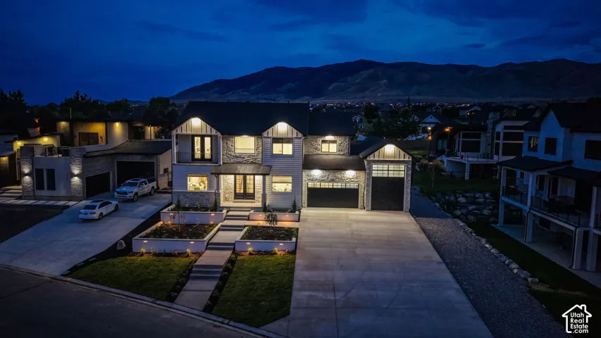 Modern farmhouse exterior with stone and siding accents, multiple gabled roofs, and an attached two-car garage