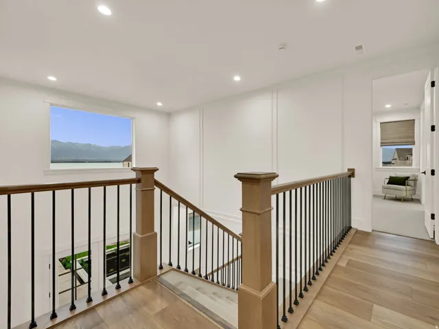 Hardwood flooring, recessed lighting, and decorative wall paneling