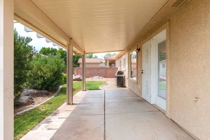 Covered patio with concrete flooring extending the full length of the home, offering sheltered outdoor space