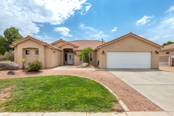Stucco exterior with a clay tile roof and arched entryway details