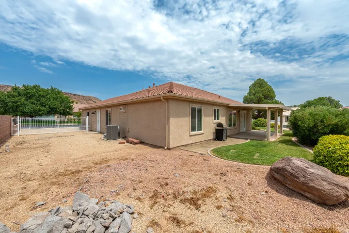 Contemporary single-story residence with stucco exterior and pitched tile roof, featuring expansive windows and covered patio areas