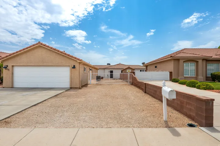 Spacious front-loading driveway with expansive gravel and concrete hardscaping providing ample parking and turning radius