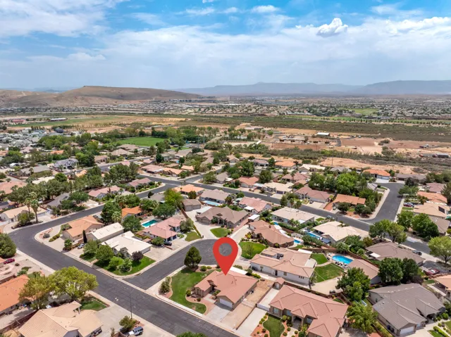 Aerial depiction of a residential neighborhood with distant mountain ranges and scattered green spaces