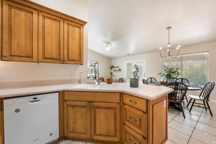 Warm wood cabinetry with raised-panel doors and a substantial island featuring multiple drawer storage and a white countertop