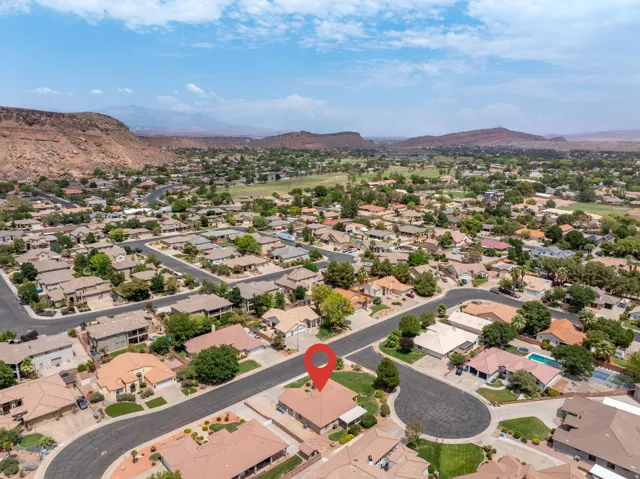 Aerial perspective of a residential neighborhood featuring single-story homes and mature landscaping