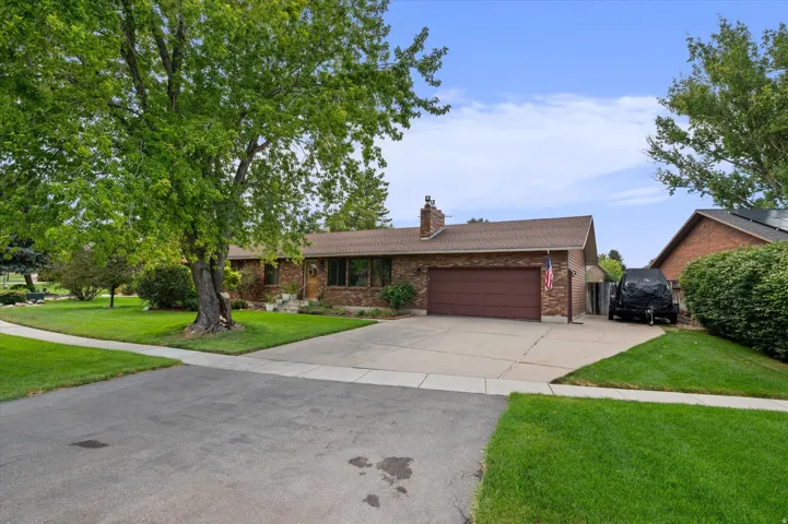 Brick ranch home with an attached two-car garage and circular concrete driveway