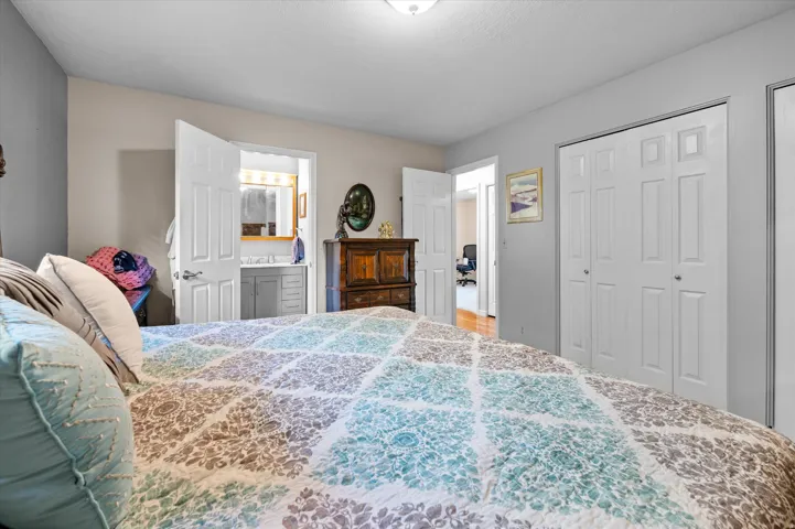 Sloped ceiling with recessed lighting, bi-fold closet doors, and wood-finish flooring