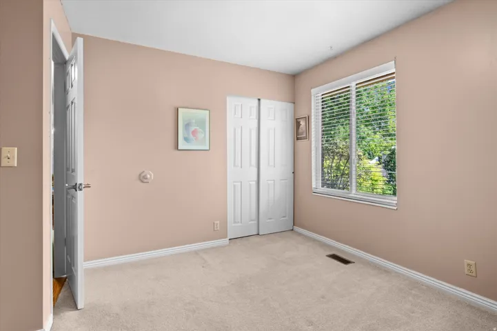 Neutral-toned walls, plush carpeting, and a double-pane window with blinds