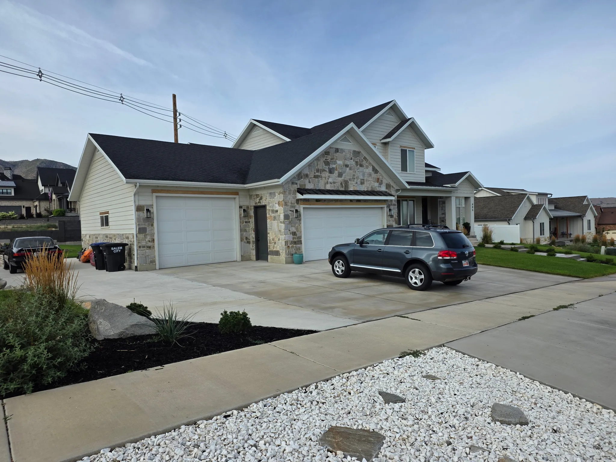 Stone and siding exterior with dark shingle roofing