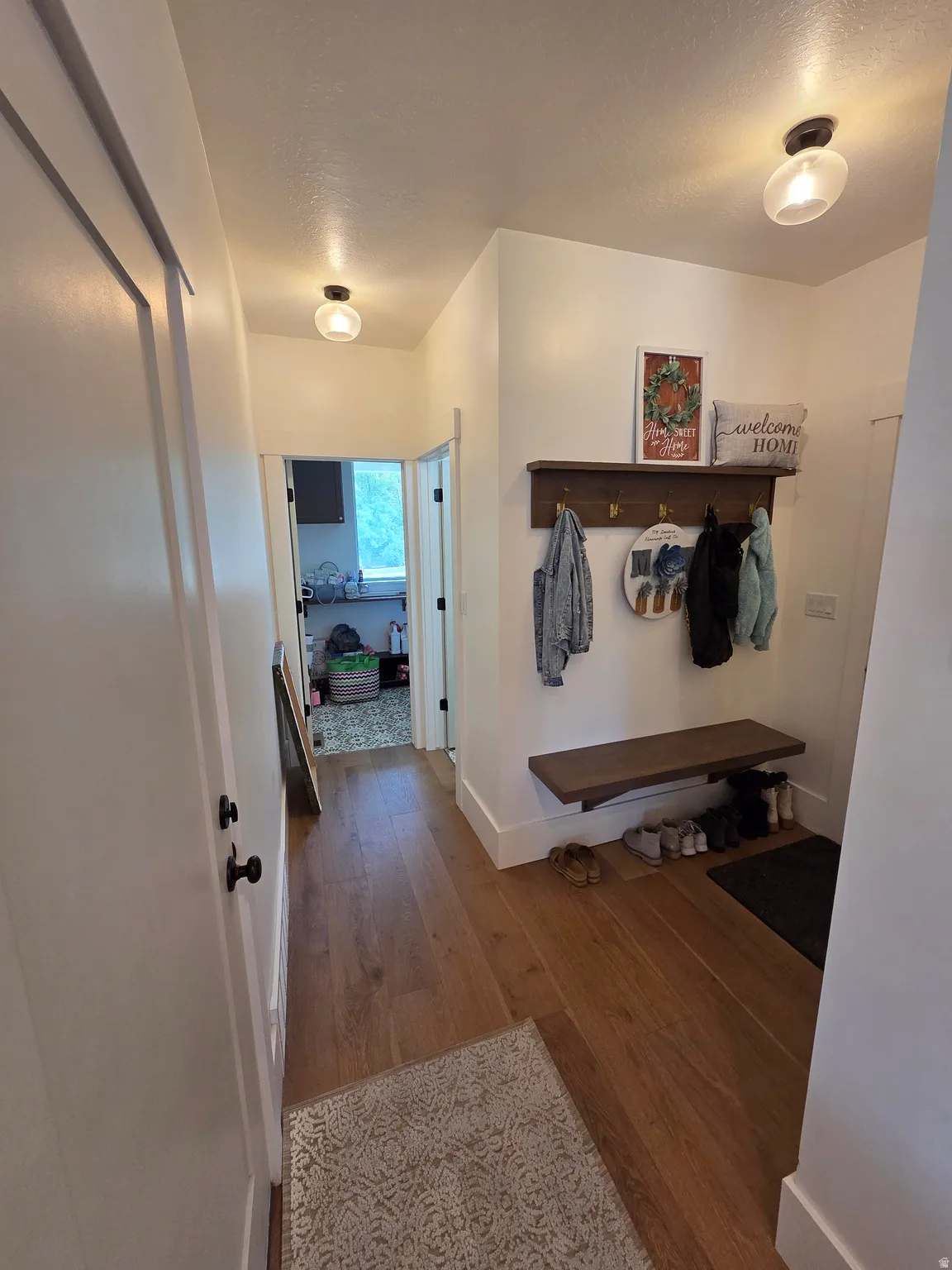 Wood-finish flooring, white walls, and contemporary ceiling light fixtures