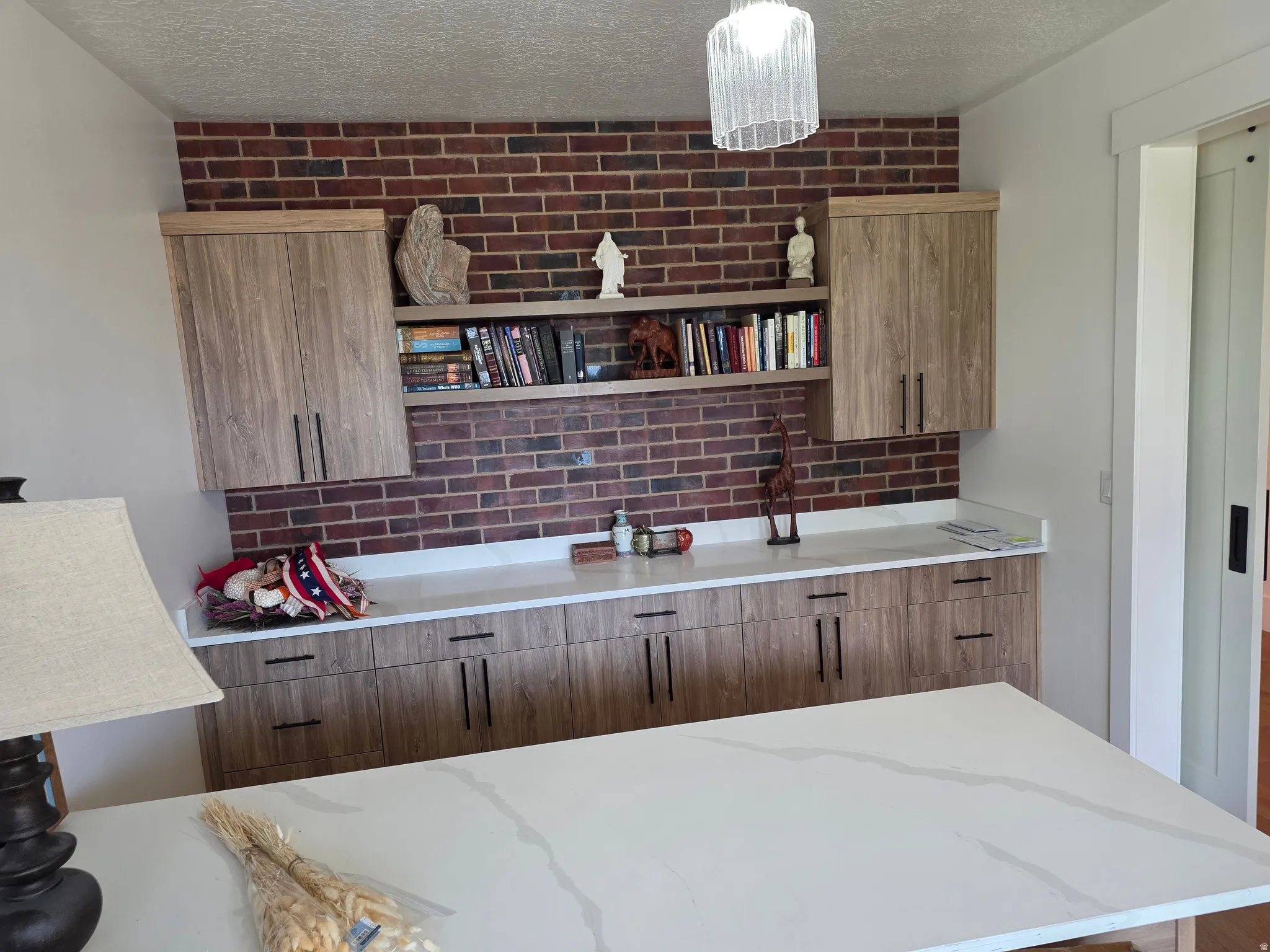 Primary Bedroom Suite with Custom Built-In Cabinetry and ShelvingThis expansive bedroom features floor-to-ceiling wood-finish cabinetry with open shelving, providing substantial storage and display space