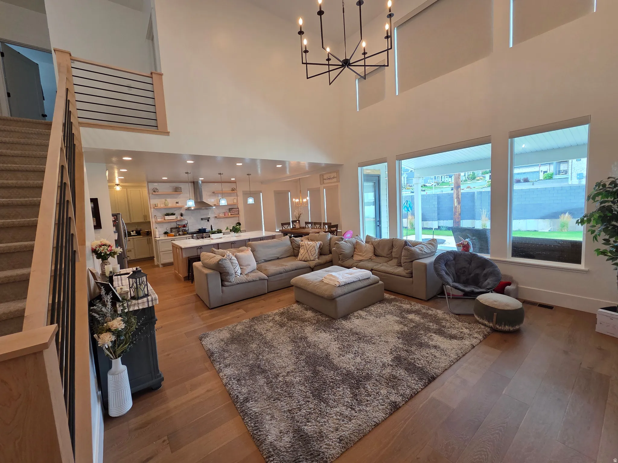Soaring vaulted ceilings with skylights illuminate this open-concept living space, featuring wide-plank wood-finish flooring throughout