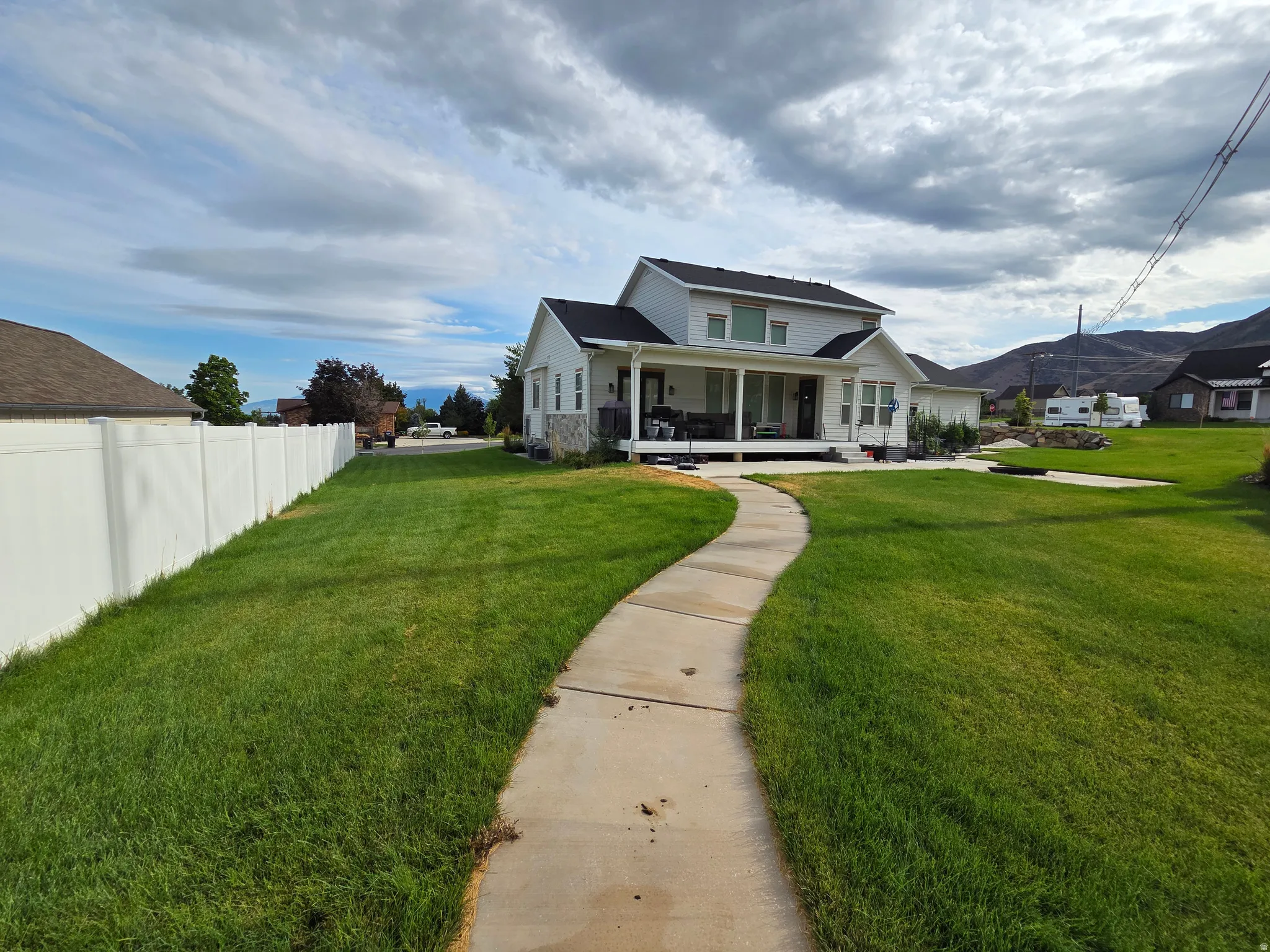 Charming two-story home with a welcoming front porch and expansive manicured lawn
