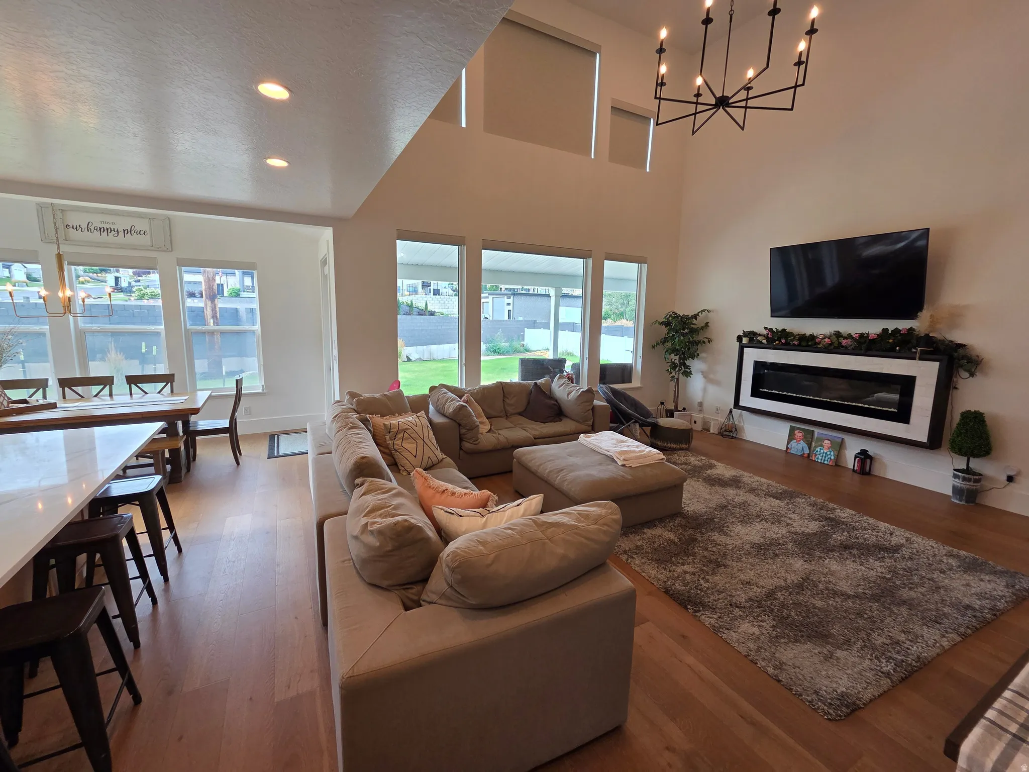 Open-concept living area featuring vaulted ceilings, recessed lighting, and a modern chandelier