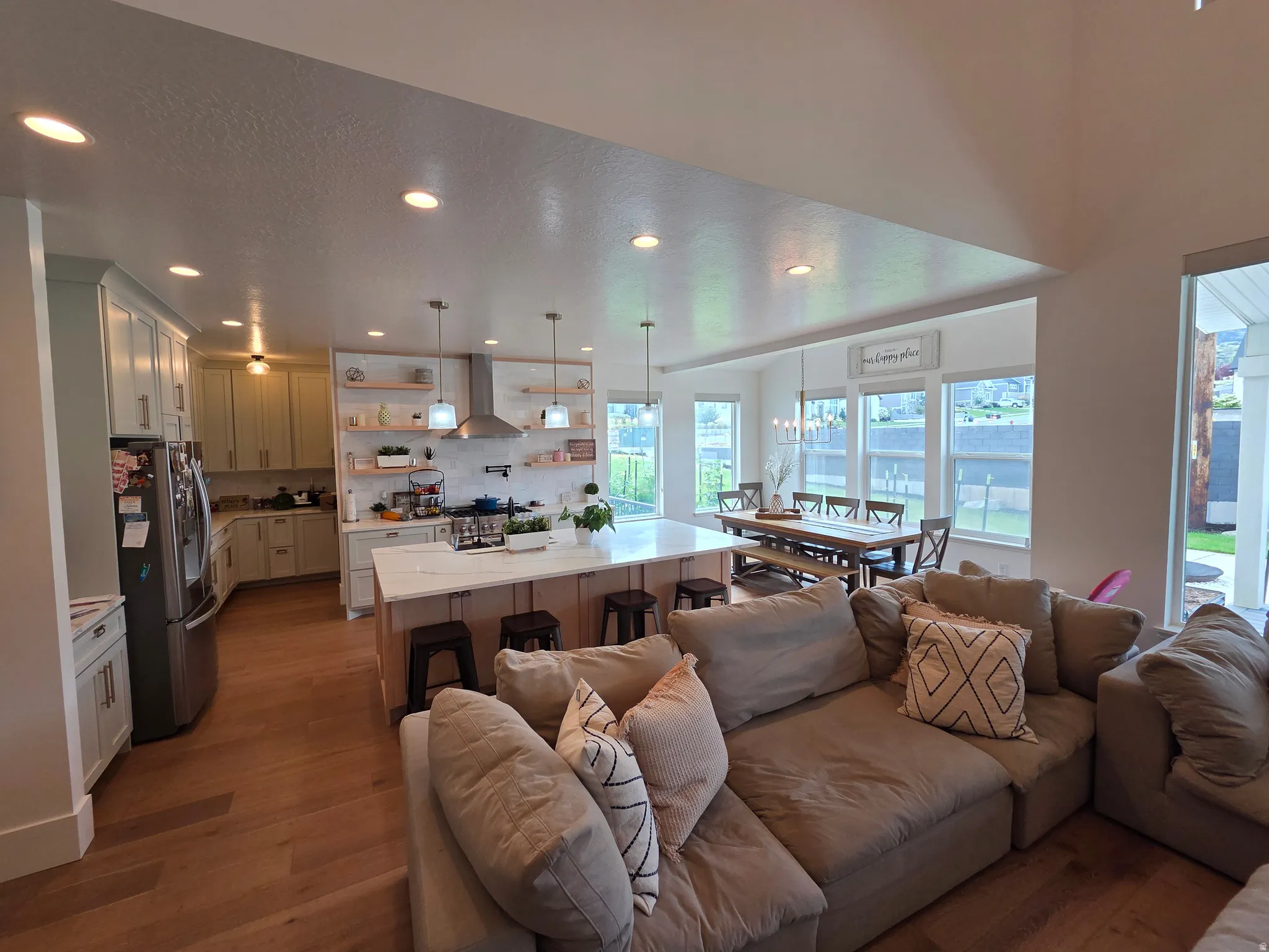 Open-concept living space featuring hardwood flooring, recessed ceiling lighting, and abundant natural light from expansive windows