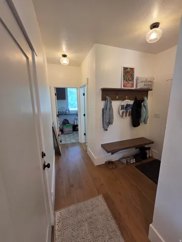 Wood-finish flooring, white walls, and contemporary ceiling light fixtures