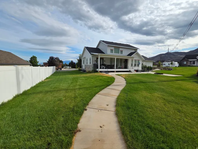 Charming two-story home with a welcoming front porch and expansive manicured lawn