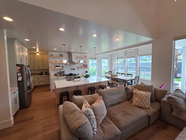Open-concept living space featuring hardwood flooring, recessed ceiling lighting, and abundant natural light from expansive windows