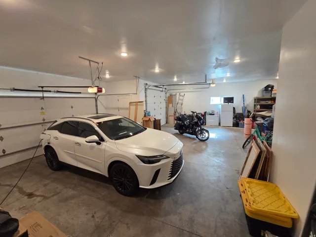 Spacious garage featuring polished concrete flooring, recessed lighting throughout, and ample storage capacity