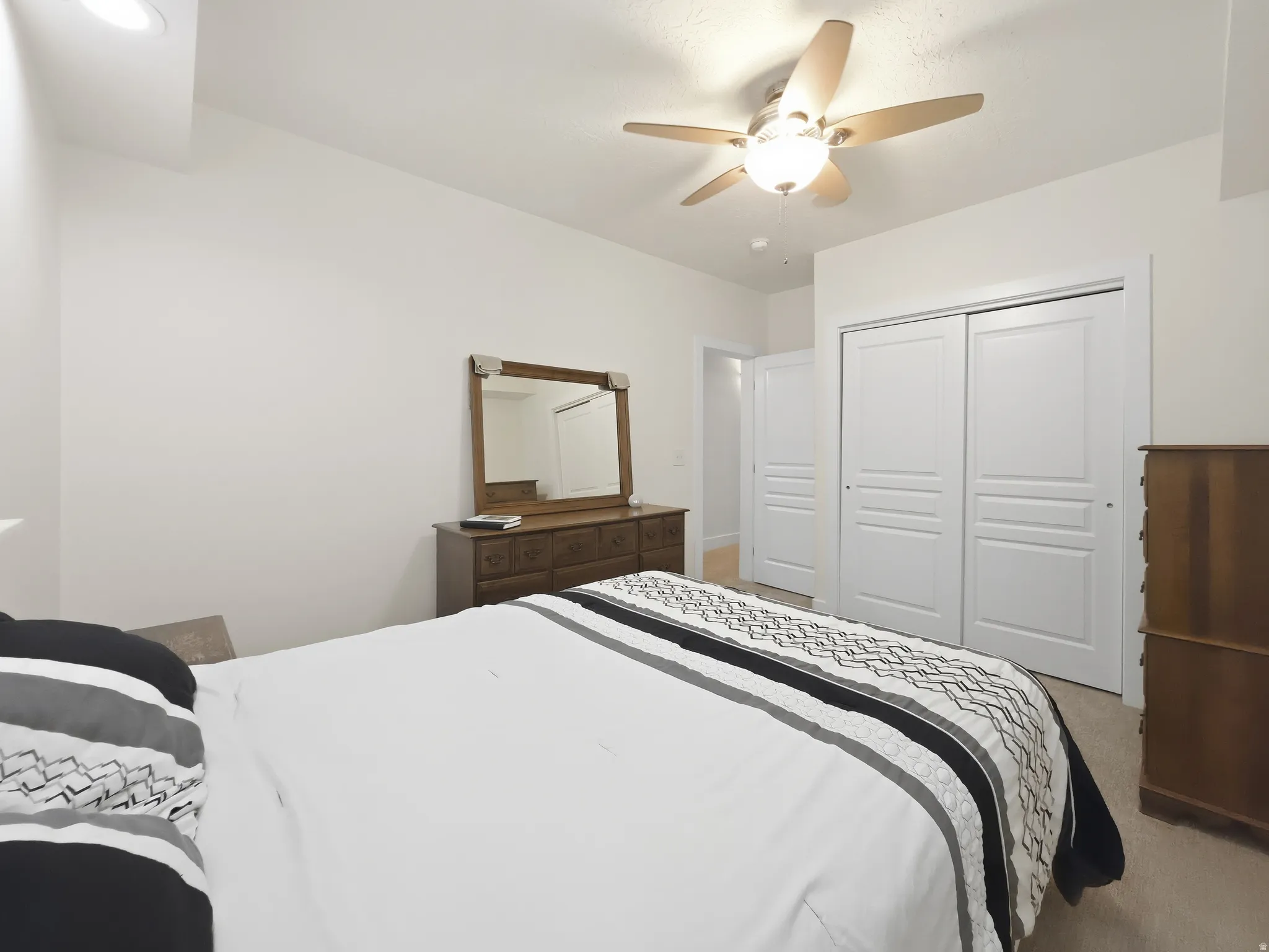 Recessed ceiling lighting, ceiling fan with integrated lighting, white interior doors, and neutral wall paint