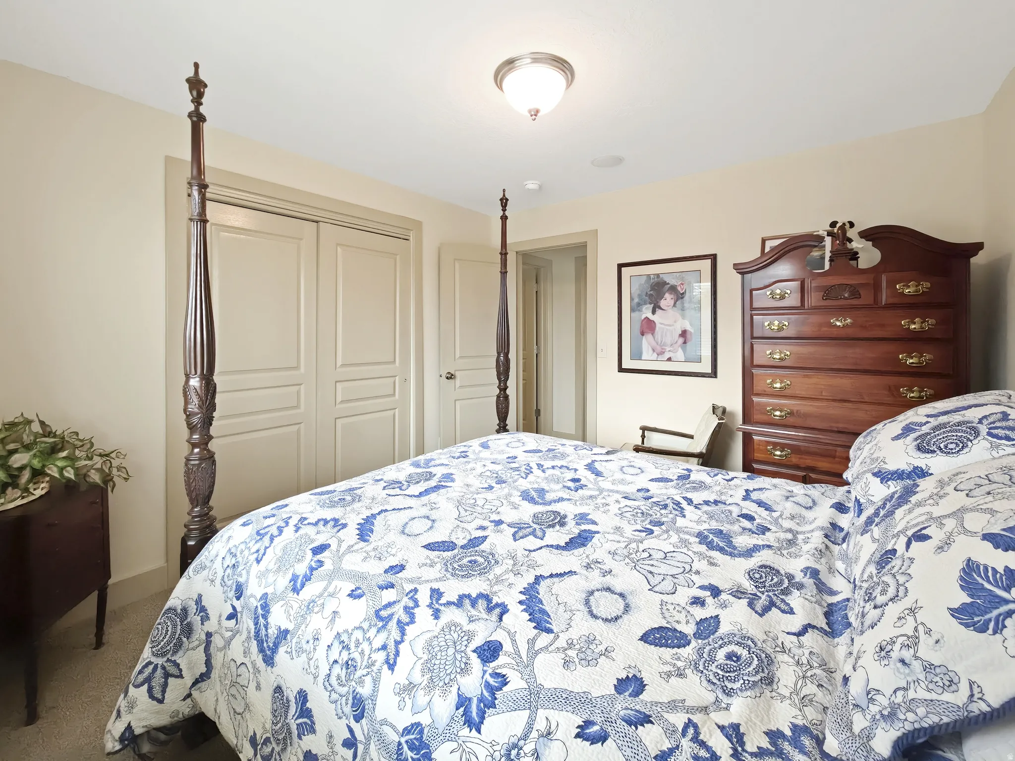 Recessed ceiling light, neutral wall colors, carpeted flooring, and a closet with bi-fold doors
