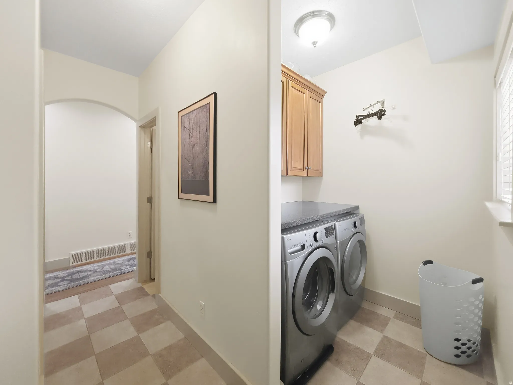 Utility area featuring a built-in countertop, upper cabinetry, and checkerboard floor tiling