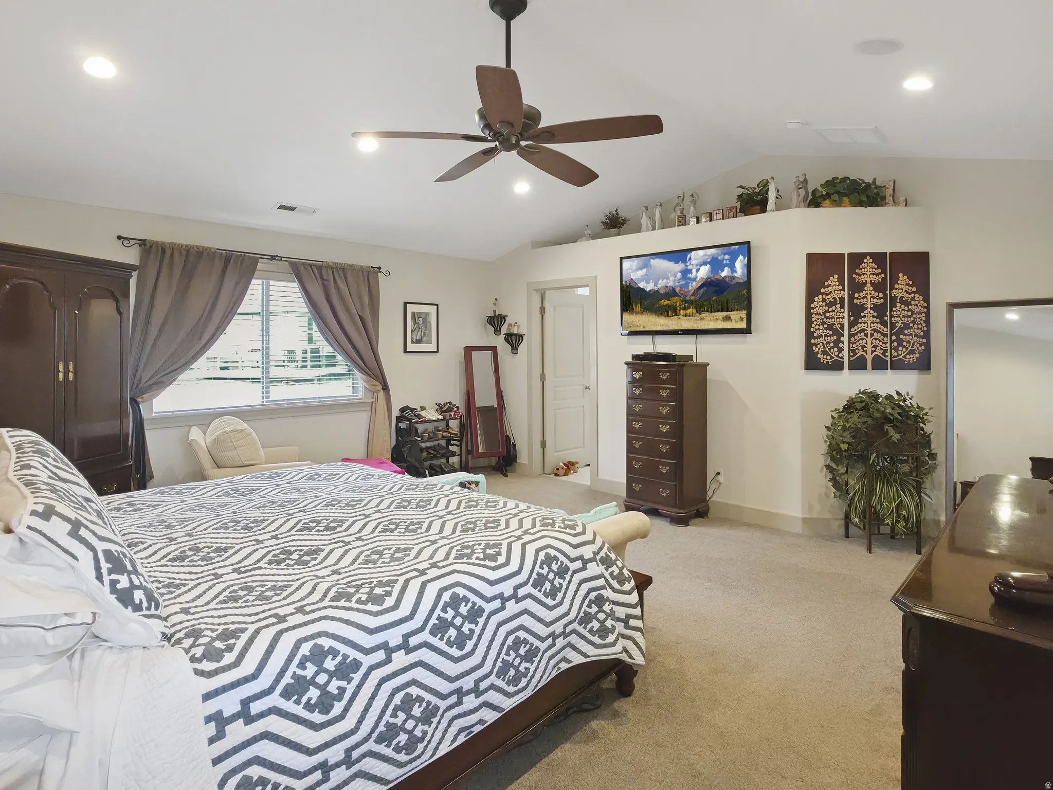 Vaulted ceiling with recessed lighting, ceiling fan, and carpeted flooring