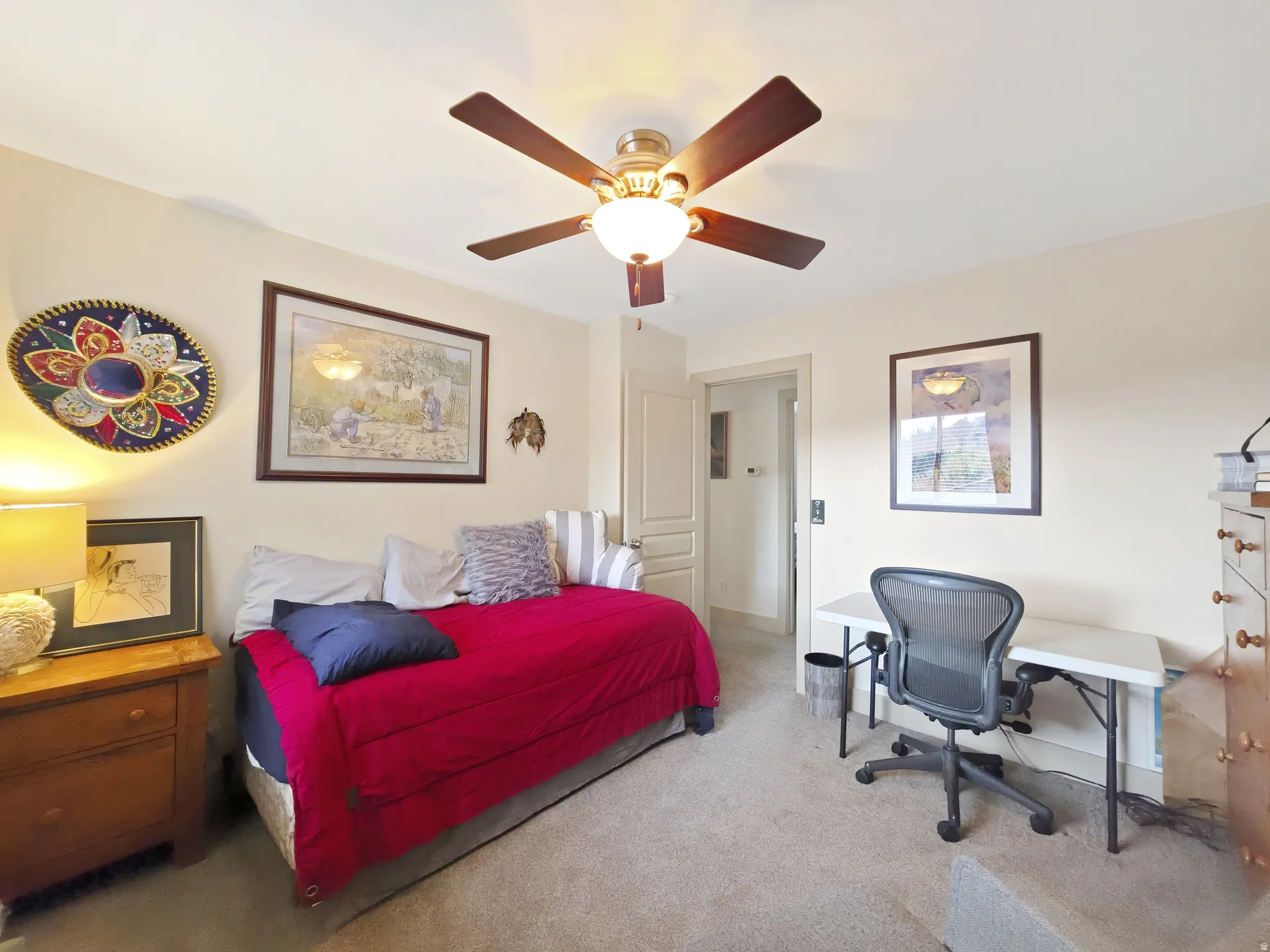 Ceiling fan with integrated lighting, neutral wall color, carpeted flooring, and a paneled interior door