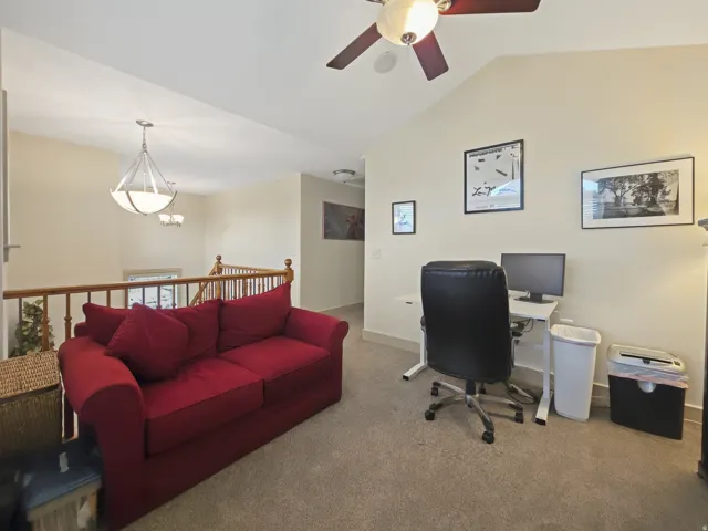 Vaulted ceiling with ceiling fan, recessed lighting, carpeted flooring, and wood railing