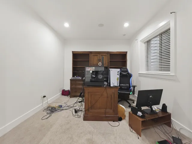 Built-in wood cabinetry with shelving, recessed lighting, white trim window, and neutral carpet flooring