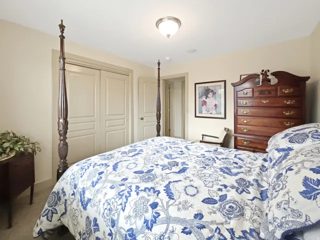 Recessed ceiling light, neutral wall colors, carpeted flooring, and a closet with bi-fold doors