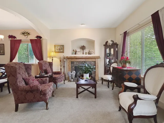 Archway entry, built-in fireplace with a stone surround, wood mantel, and arched alcove
