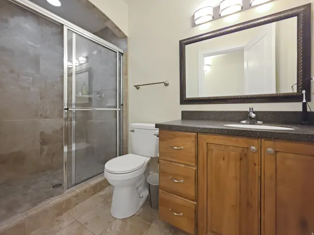 Shower with sliding glass enclosure, tile walls, and tiled floor