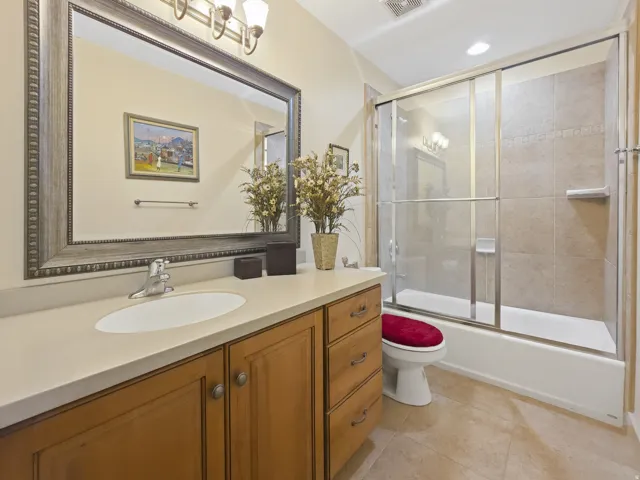 Vanity with wood-finish cabinetry, light-toned countertop, and integrated sink