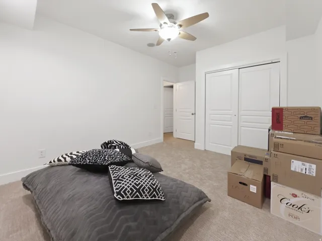 Recessed lighting, ceiling fan with integrated lighting, neutral carpet flooring, white painted walls, and white bi-fold closet doors