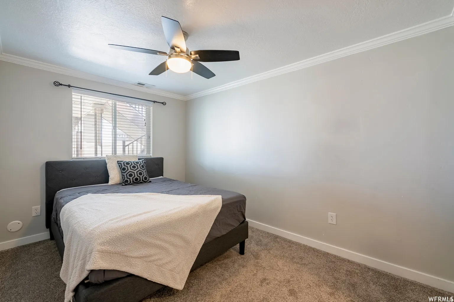 Recessed window with blinds, ceiling fan with integrated lighting, crown molding, and neutral wall tones
