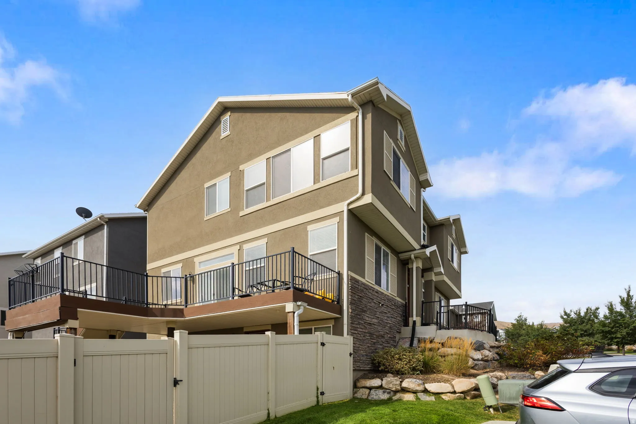 Stucco exterior featuring multiple windows and a stone accent facade
