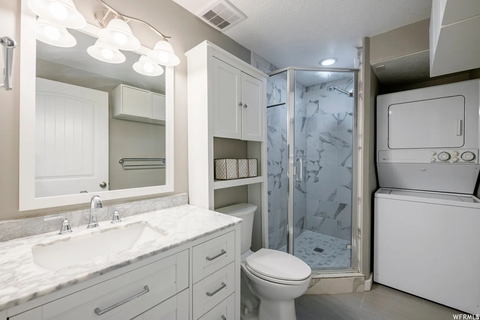 White shaker vanity with a marble countertop, undermount sink, and chrome fixtures