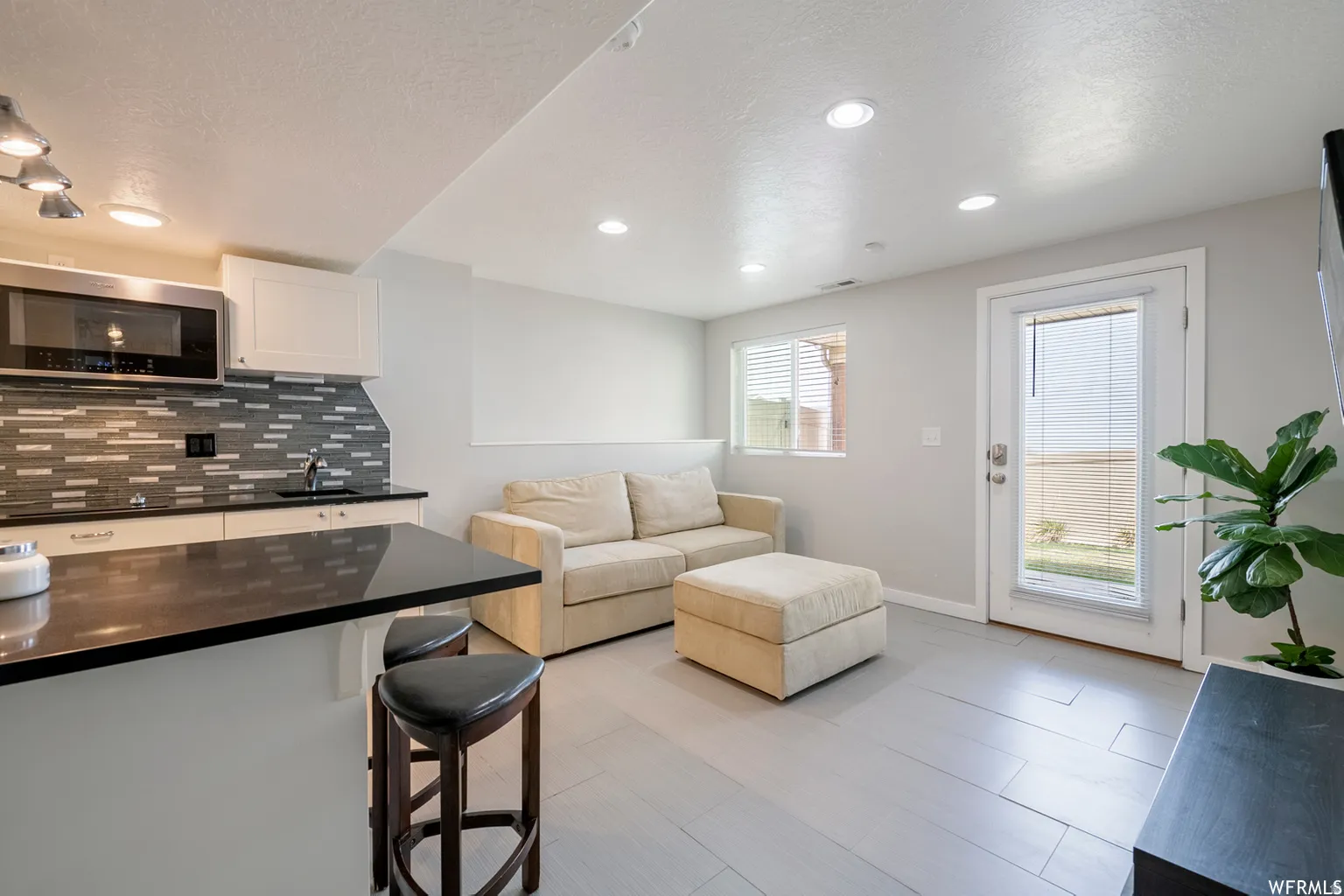 2nd Kitchen with dark countertops, white cabinetry, and a stainless steel microwave