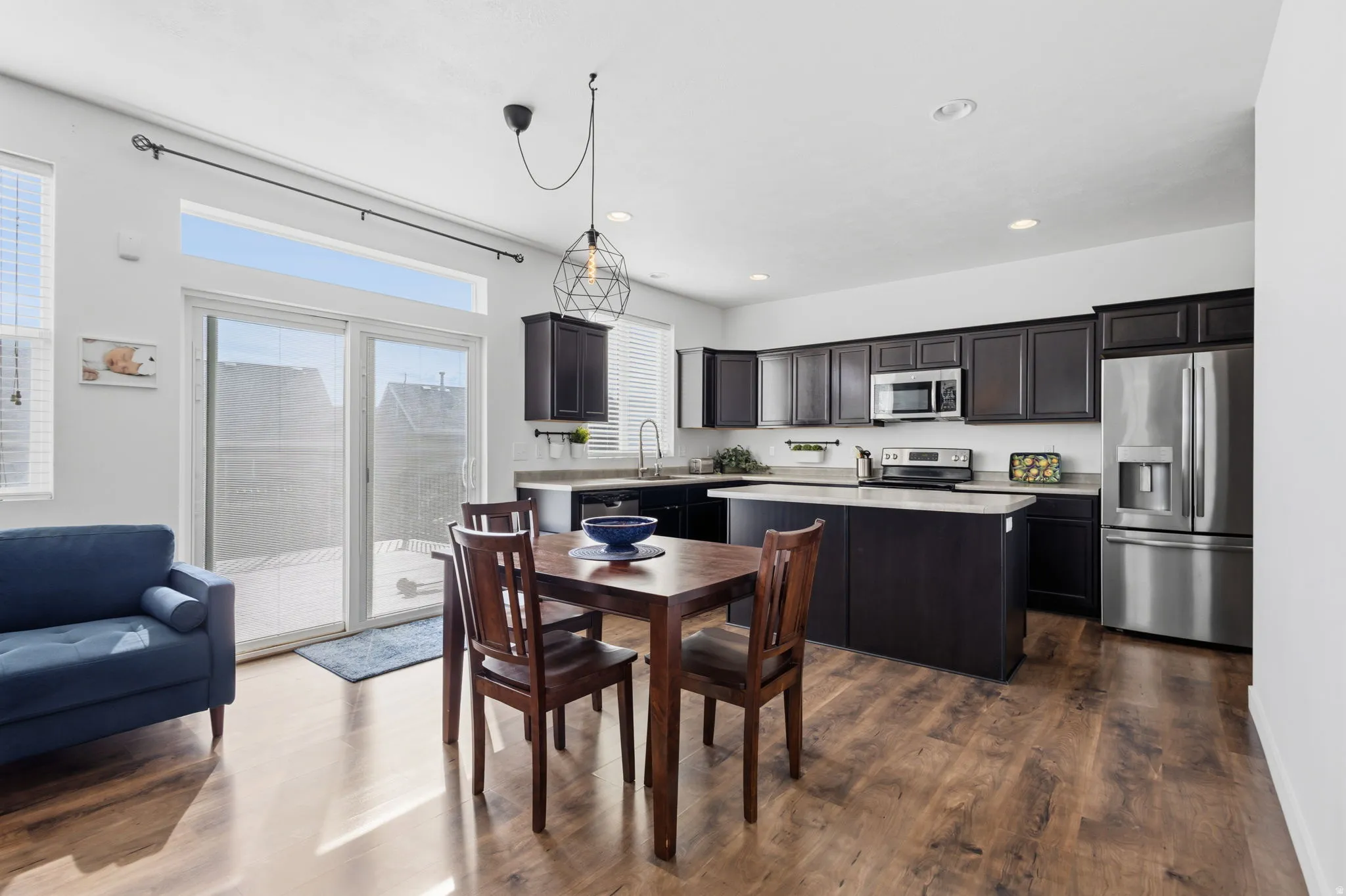Kitchen featuring dark wood cabinetry, stainless steel appliances, and light-toned countertops