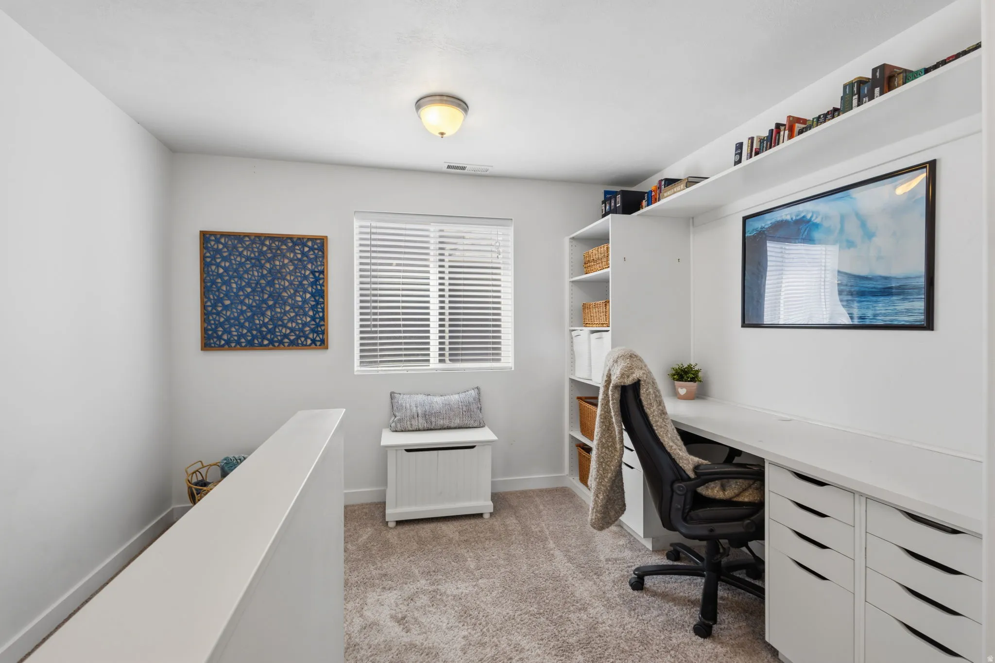 Modern home office featuring built-in cabinetry with multiple storage drawers, a floating desk surface, and shelving for organization