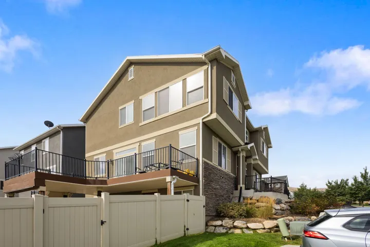 Stucco exterior featuring multiple windows and a stone accent facade