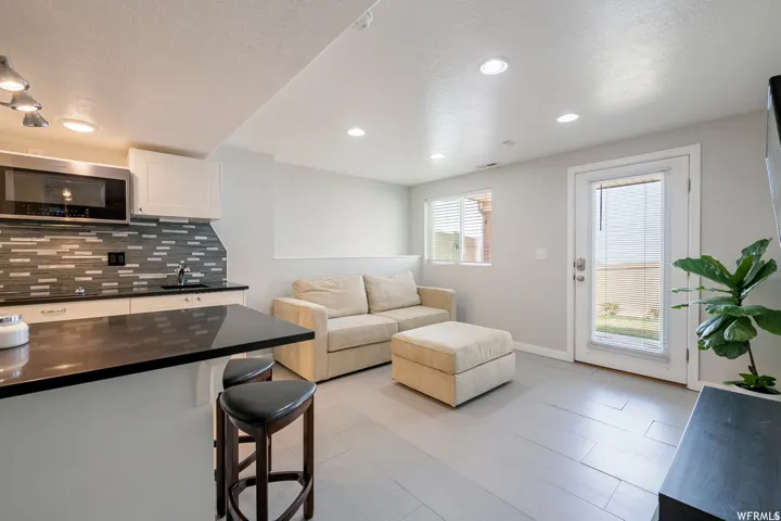 2nd Kitchen with dark countertops, white cabinetry, and a stainless steel microwave